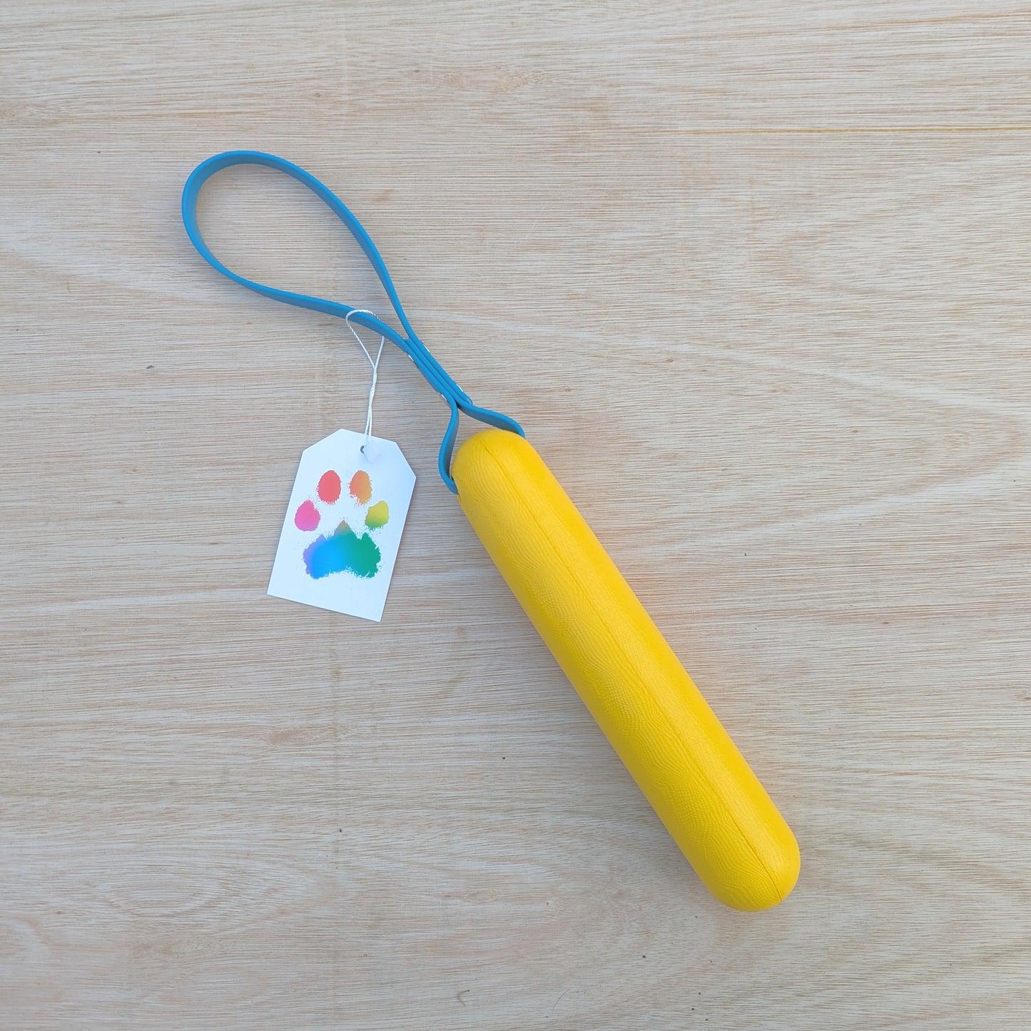 A yellow foam buoy dog tug toy with a blue BioThane handle