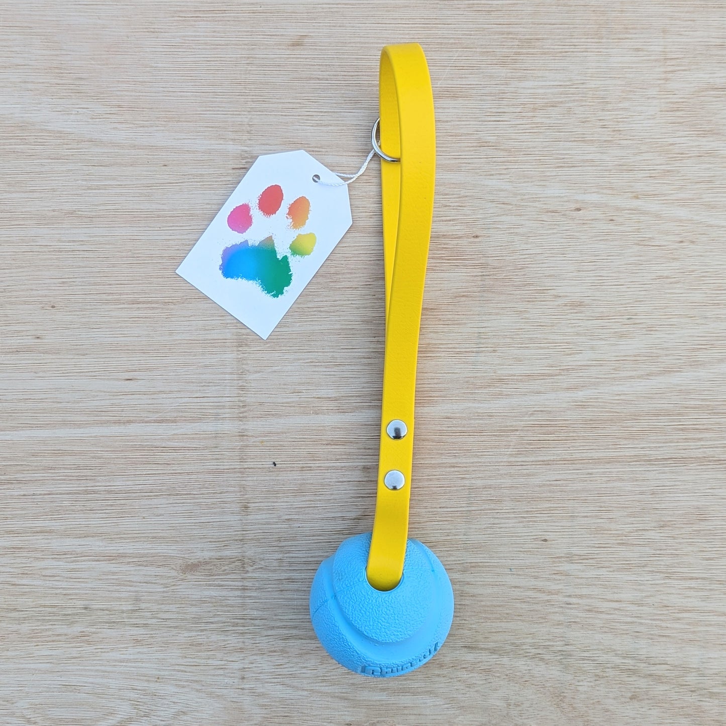 a blue ball with a yellow handle n it's side to show the silver hardware on the handle
