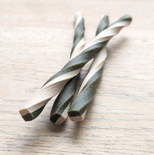 three apple and spinach veg chew twists, one is lying on top of the others. Close up of the ends of the twists