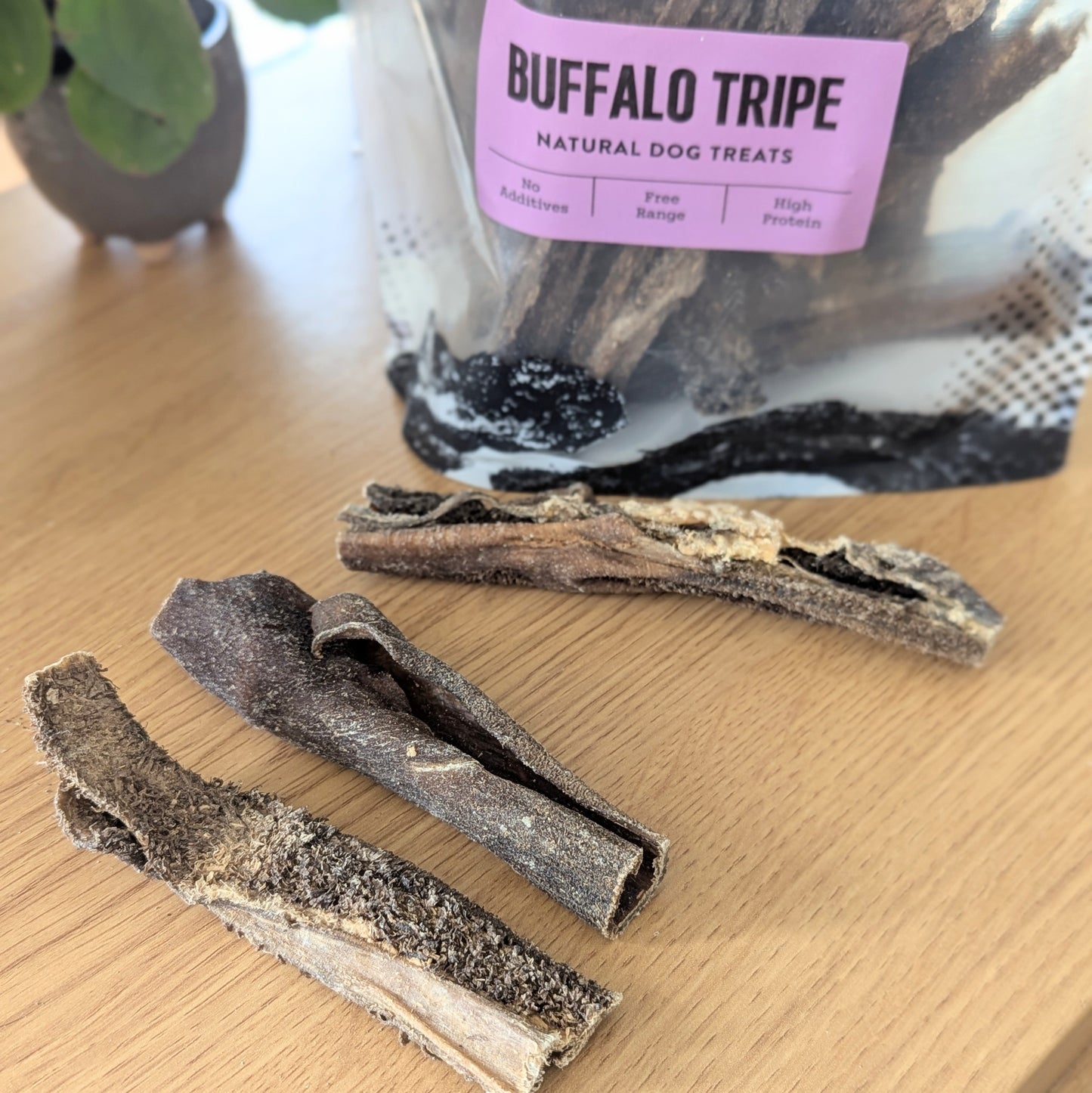 three pieces of tripe are in front of the bag, the purple label stating "buffalo tripe" is visible at the top of the photo. The tripe is dark and looks like thick sticks