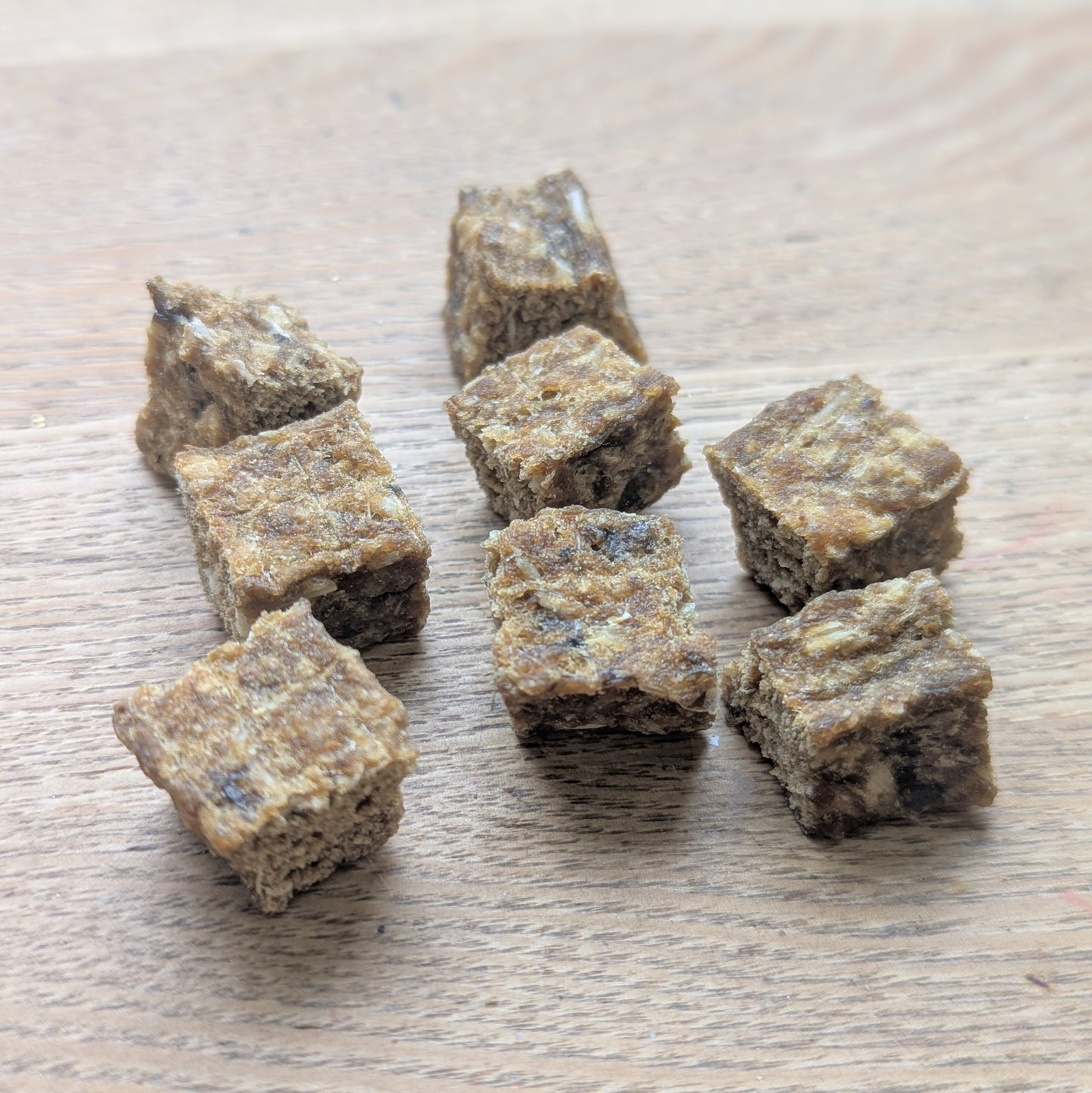 a close up of 8 cod cubes, they are brown and rough in texture