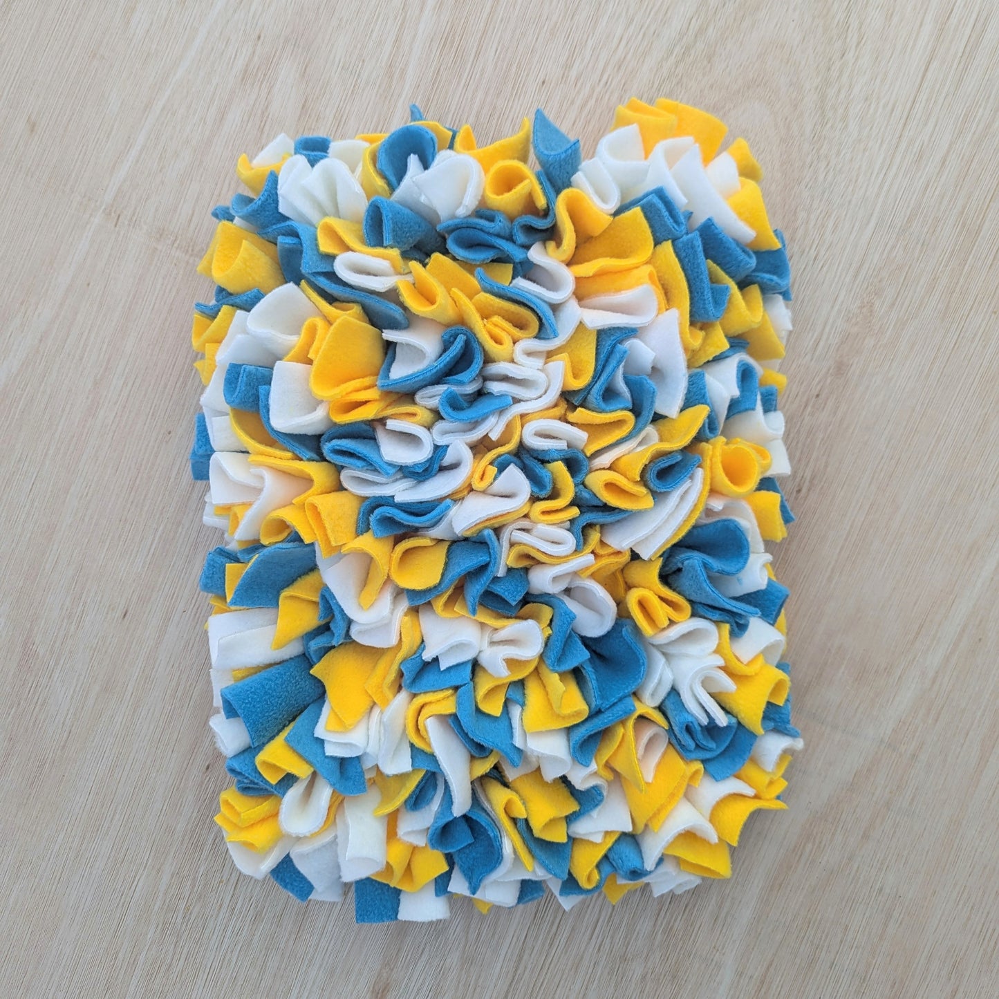 a large blue yellow cream snuffle mat