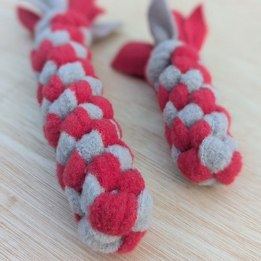a close up of two woven fleece tug scent toy, both are red and grey
