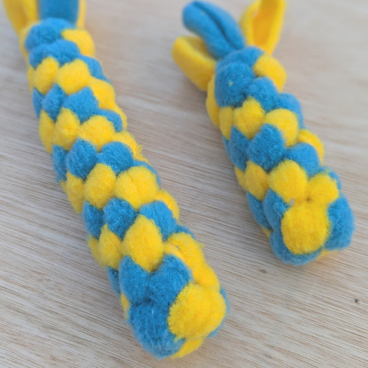 a close up of two woven fleece tug scent toy, both are blue and yellow