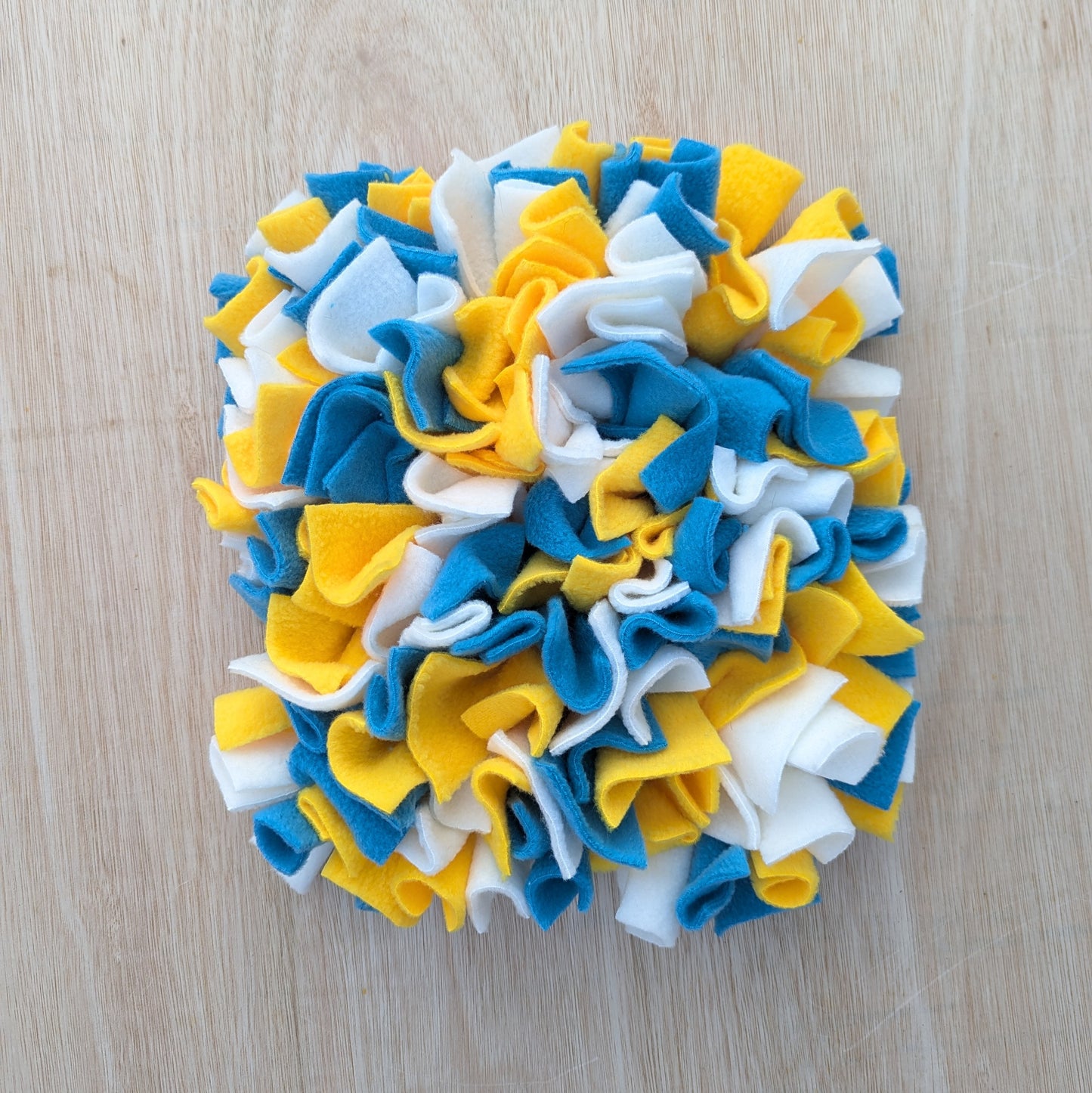 a small blue yellow cream snuffle mat