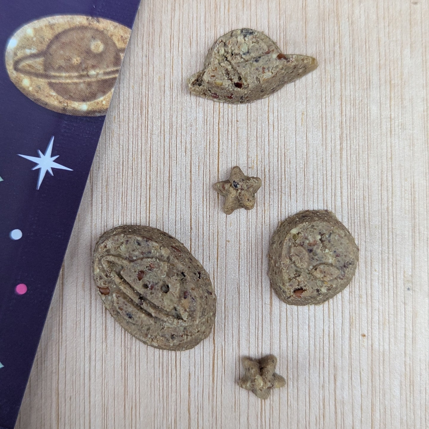 Denzels space mix treats shaped like planets and stars on a wooden surface.