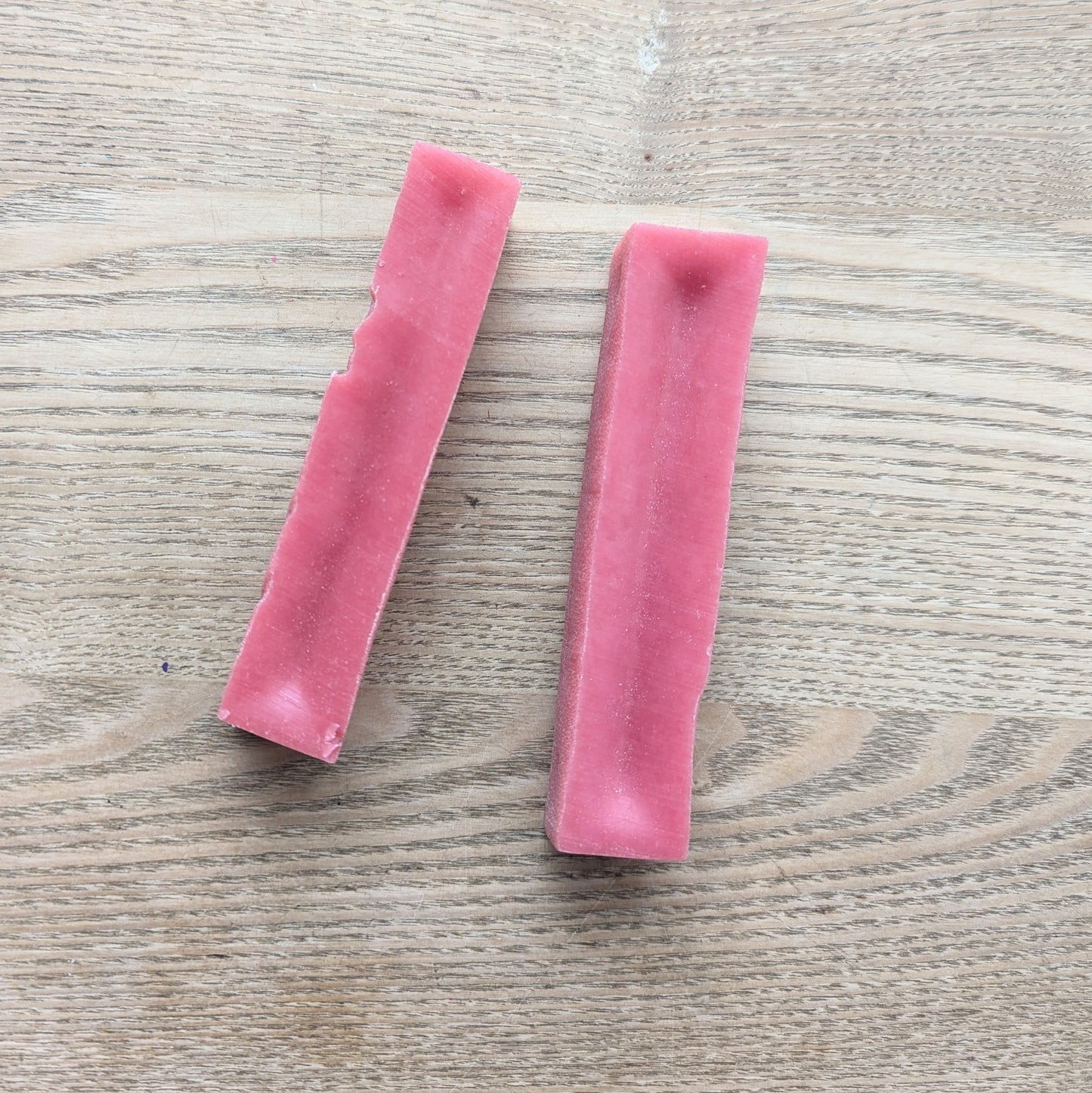 two medium strawberry Yakers yak bars lying next to each other. They are a darker pink colour