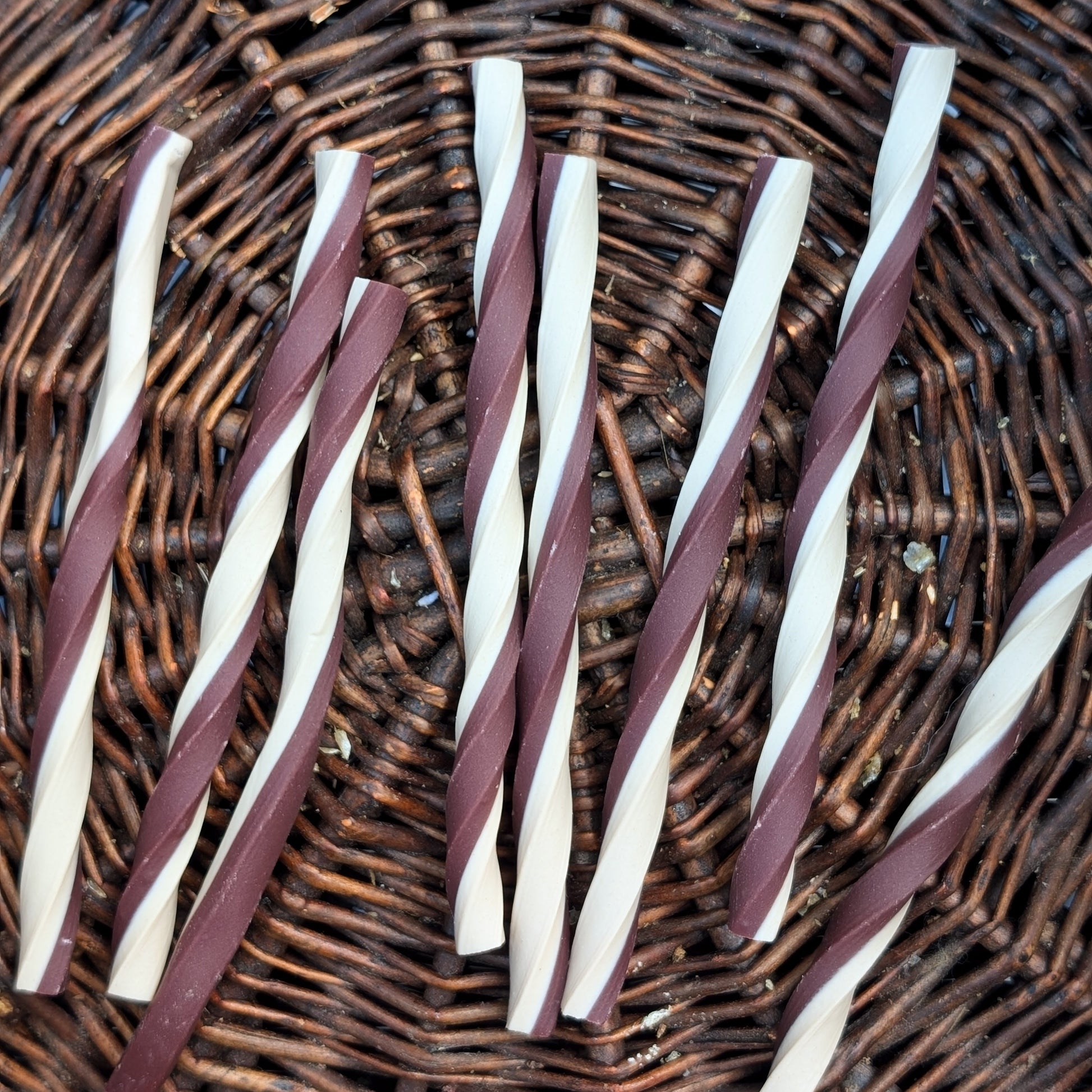Twisted purple and white sticks on a wicker surface