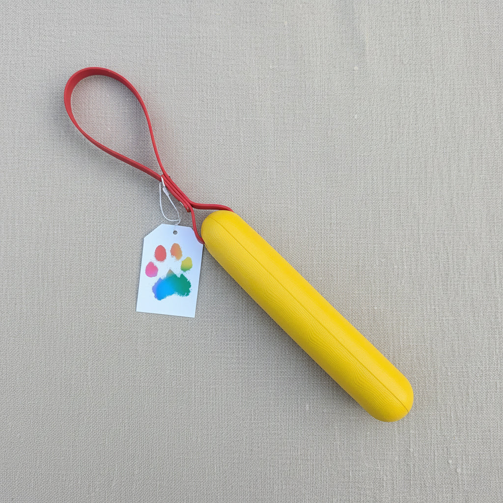 A yellow foam buoy dog tug toy with a red BioThane handle 