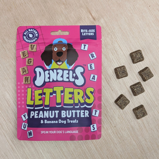 Denzel's Letters peanut butter and banana dog treats packaging with treats on a wooden surface