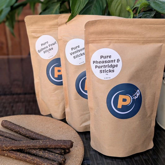 Three packages of Pure Guinea Fowl Sticks, Pure Venison Sticks, and Pure Pheasant & Partridge Sticks with a visible brand logo.