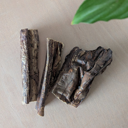 Three pieces of dried beef lung on a light surface with a green leaf in the corner. They are lying next to each other
