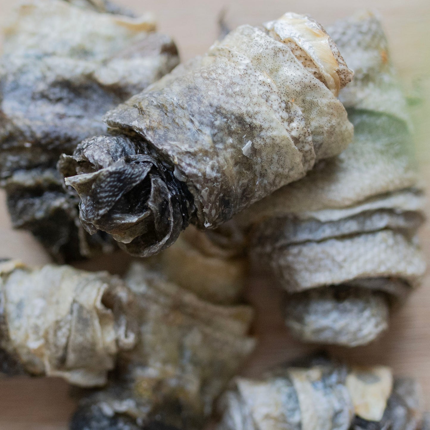 there are several cod skin rolls, taking up the entire photo. The camera is focused on the roll on top of the others, the rest are blurred 