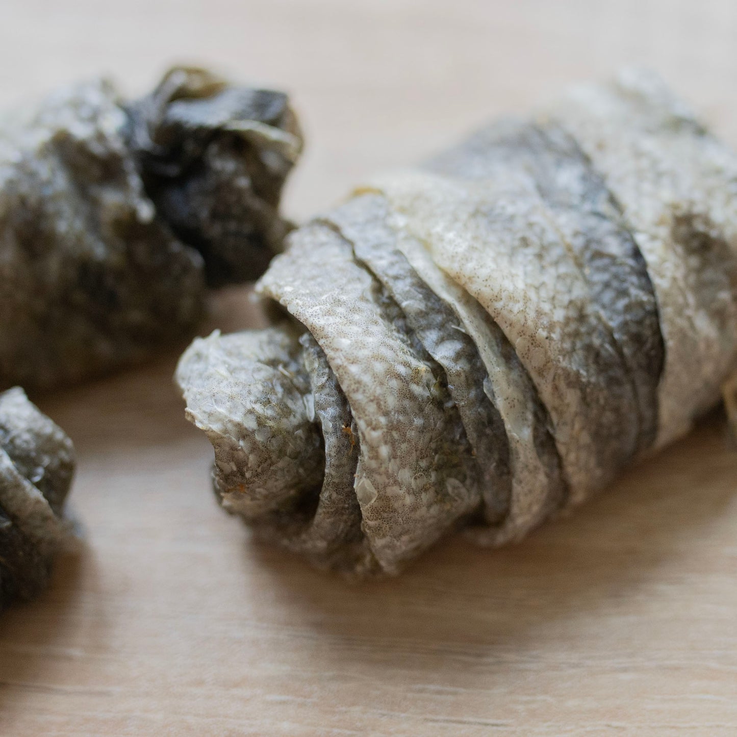 A close up of a cod skin roll. You can see the layers, it looks like fishy croissant without the ends curled. They are a third of the size of said croissant 