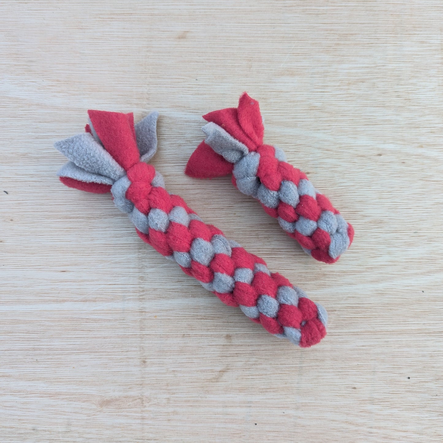 two woven fleece tug scent toy, both are red and grey