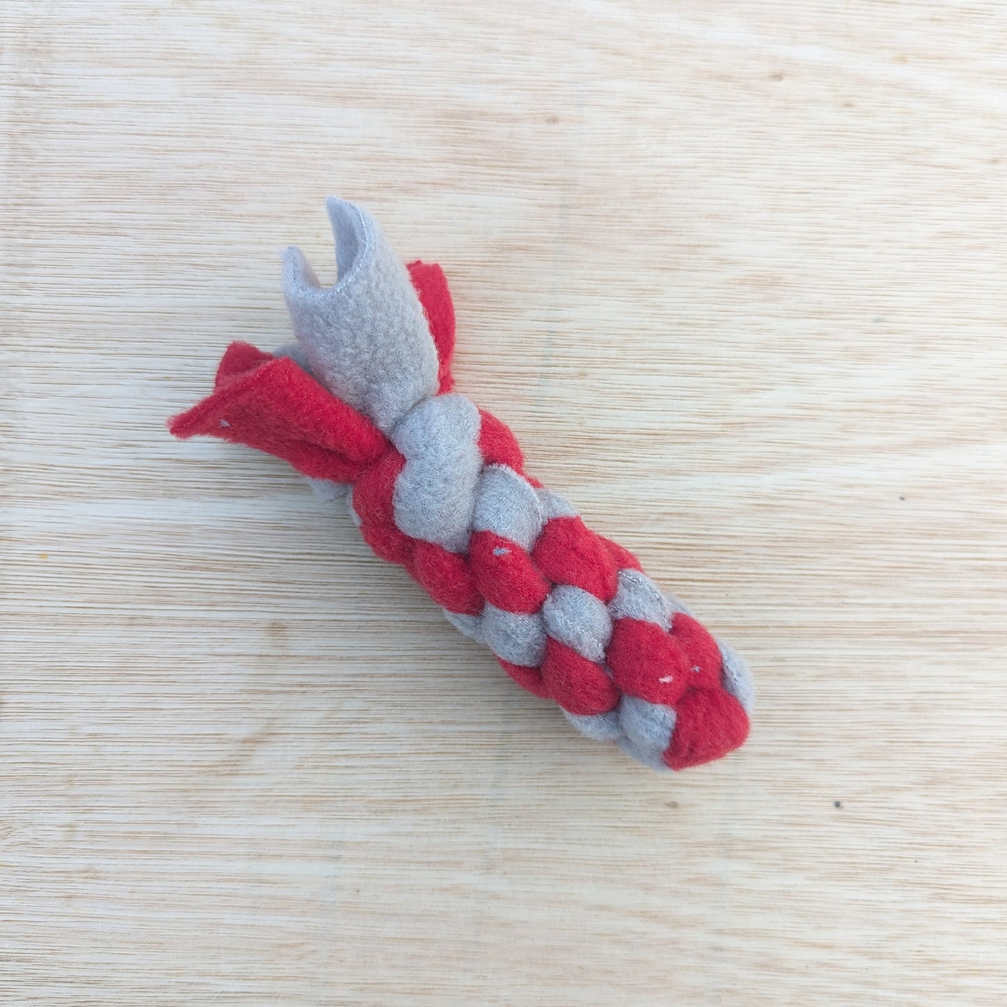 a 10cm red and grey, woven fleece tug scent toy