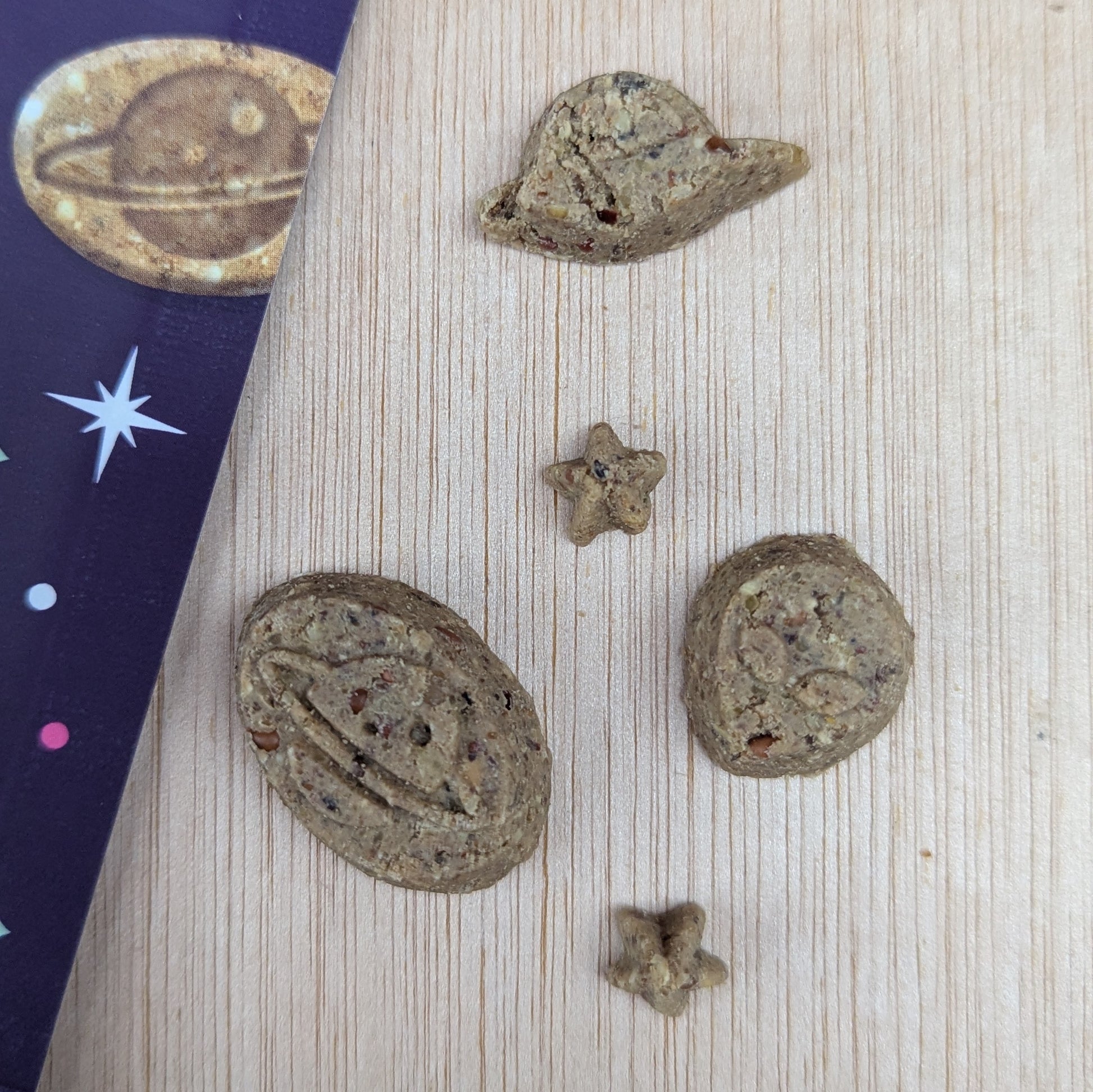 Denzels space mix treats shaped like planets and stars on a wooden surface.