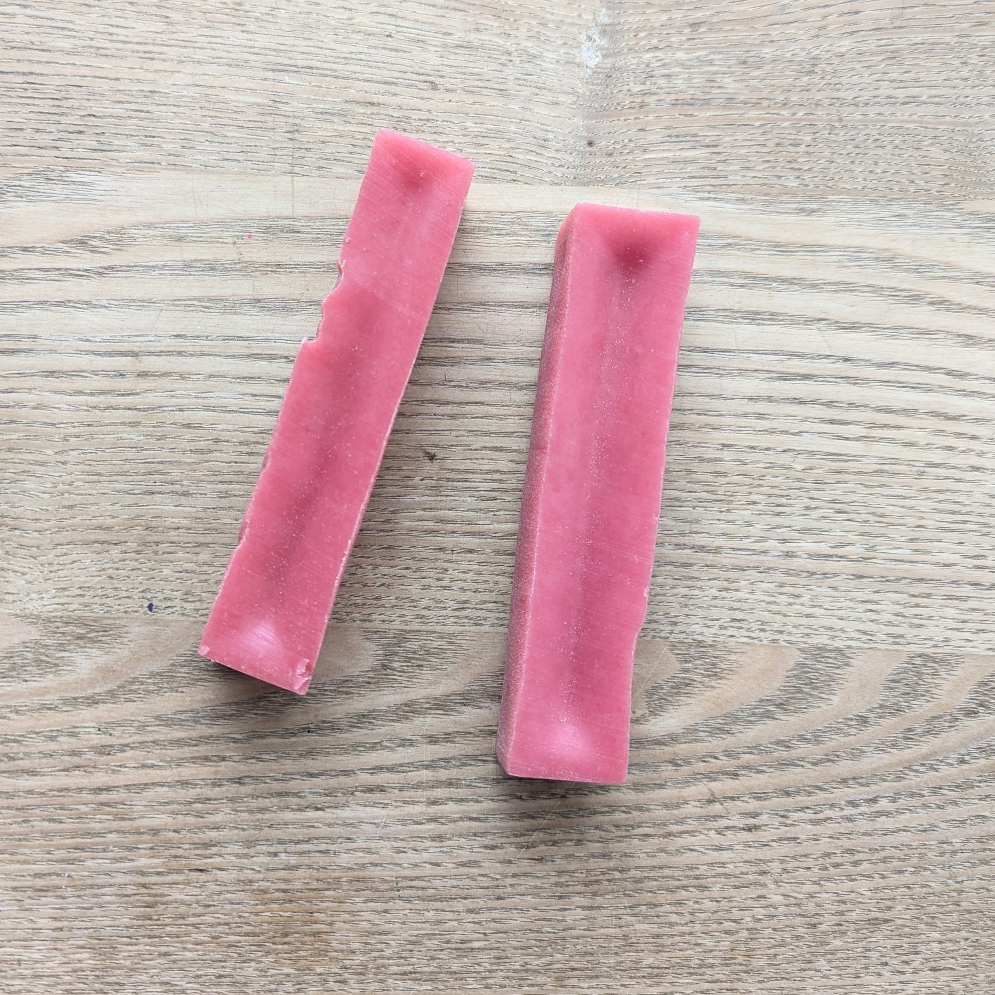 two medium strawberry Yakers yak bars lying next to each other. They are a darker pink colour